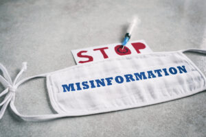 A medical mask with the word "misinformation" written across it