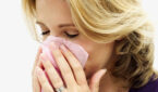 close-up of a woman holding a tissue to her nose