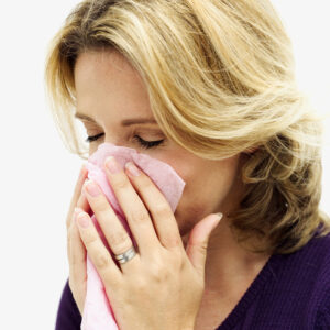 close-up of a woman holding a tissue to her nose