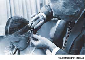 William F. House, MD, with Tracy Husted, the first pediatric cochlear implant patient (Los Angeles, 1981).